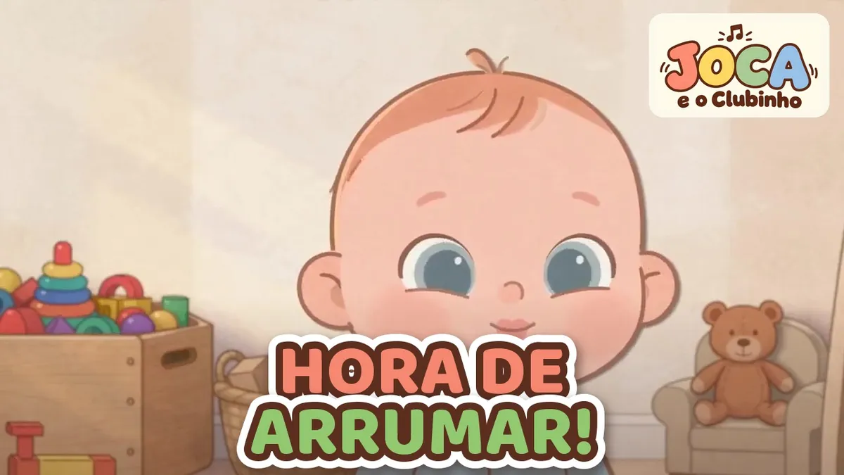 Joca sorri no quarto ao lado de um baú de madeira cheio de brinquedos e de um urso de pelúcia na poltrona, no clipe Cada Coisa no Seu Lugar